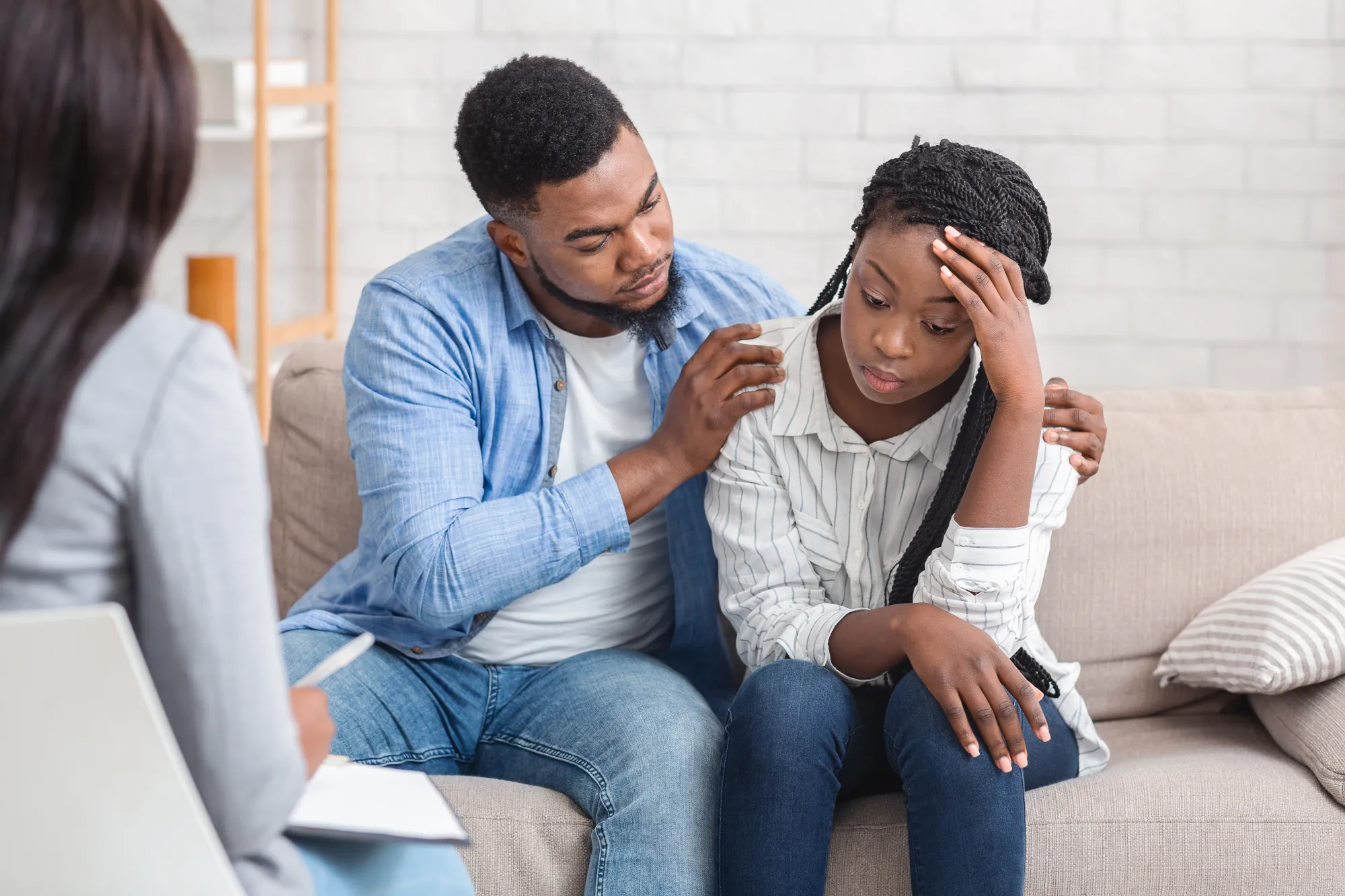 husband supporting his depressed wife during psychotherapy session with counselor husband supporting his depressed wife